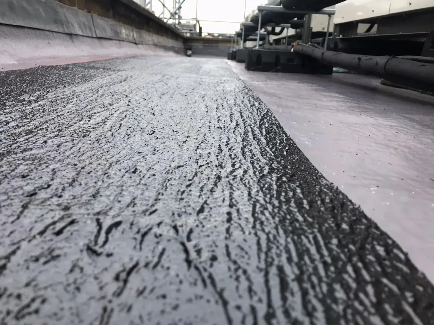 RESGRIP anti-slip coating in black, applied on a flat roof